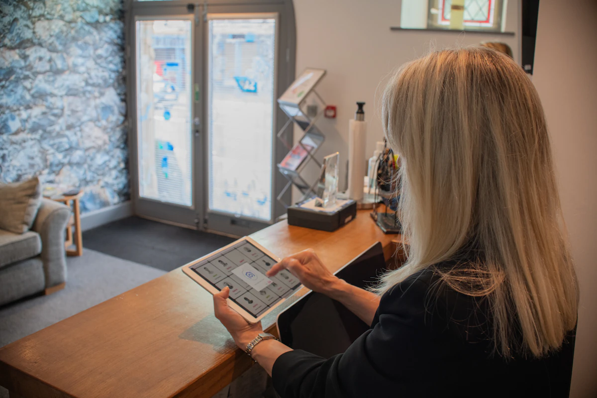 A receptionist using a tablet at a clinic front desk
